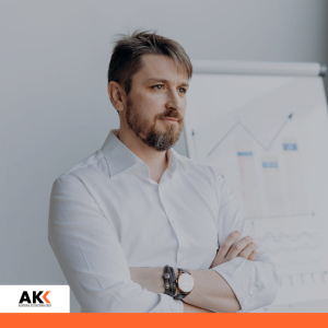 Mężczyzna analizujący dane przy tablicy z wykresami, symbolizujący procesy transformacji biznesowej.