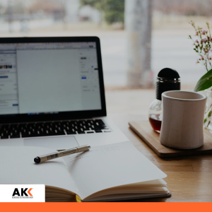 Laptop, notes i kawa na biurku, symbolizujące codzienną pracę z dokumentacją podatkową.