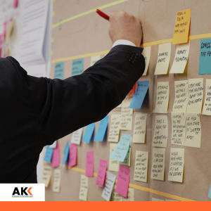 Osoba planująca i analizująca procesy na tablicy z karteczkami, symbolizująca organizację i rozliczanie VAT w różnych obszarach działalności.