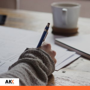 Osoba sporządzająca notatki przy biurku, symbolizująca przygotowanie do kontroli podatkowych.