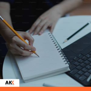 Osoba robiąca notatki przy laptopie, symbolizująca rozwój kompetencji i planowanie strategiczne.