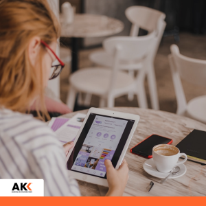 Kobieta korzystająca z tabletu w kawiarni, symbolizująca pracę z narzędziami cyfrowymi i AI.