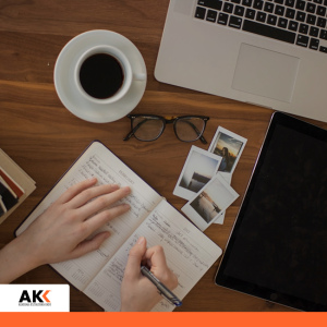 Biurko z laptopem, notatnikiem i kawą, symbolizujące uporządkowaną pracę administracyjną.