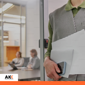 Osoba trzymająca dokumenty i telefon w biurze, symbolizująca wdrażanie systemów i pracę z dokumentacją.