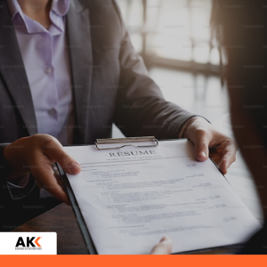 Osoba przekazująca dokumenty podczas spotkania, symbolizująca procesy księgowe i zarządzanie informacją.