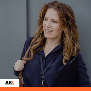 Uśmiechnięta kobieta w środowisku biznesowym, symbolizująca dobrą komunikację i relacje w pracy.