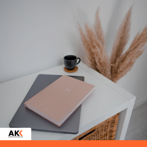 Minimalistyczne biurko z notesem i laptopem, symbolizujące analizę finansową i zamknięcie roku.