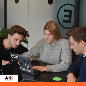 Zespół analizujący dane przy laptopie, symbolizujący współpracę i zarządzanie podatkami w grupach kapitałowych.