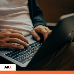 Osoba pracująca przy laptopie, symbolizująca analizę rozliczeń podatkowych w sektorze nieruchomości.