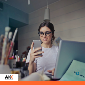 Młoda kobieta w okularach korzysta ze smartfona i laptopa – szkolenie przeciwdziałanie mobbingowi i dyskryminacji Kołobrzeg