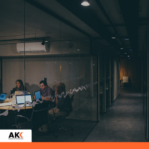 Specjaliści ds. kadr i płac podczas wieczornej sesji warsztatowej w nowoczesnym biurze – Akademia Kształcenia Kadr.