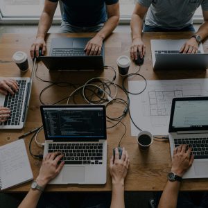 Zespół pracujący na laptopach podczas warsztatów z umiejętności cyfrowych i narzędzi AI – Akademia Kształcenia Kadr.