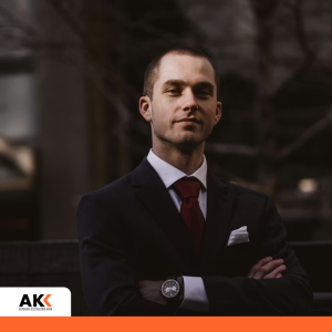 Meneżdzer stoi dumny i pewny siebie z uśmiechem na twarzy w garniturze